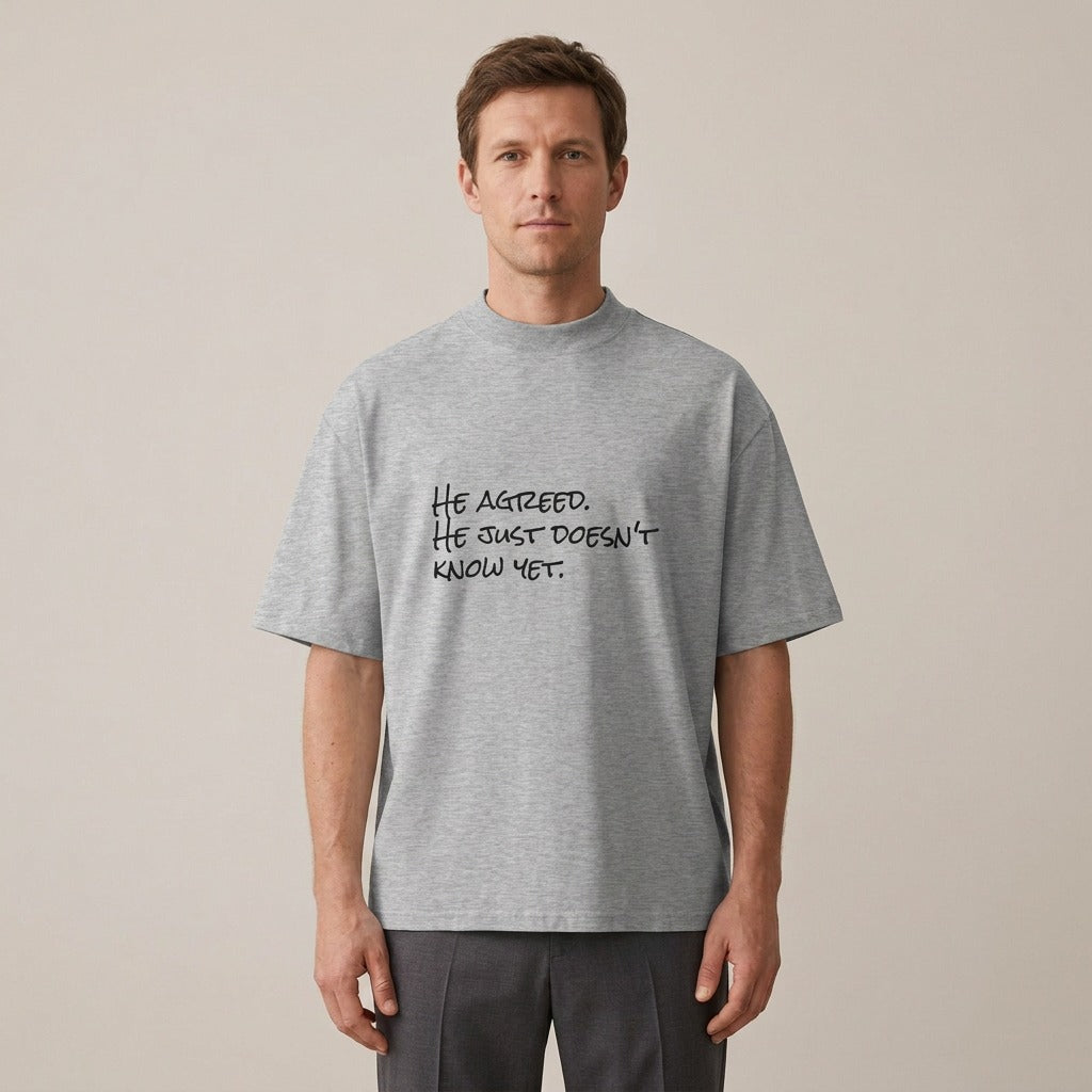 Model wearing the He Agreed. He Just Doesn't Know Yet. t-shirt in heather grey