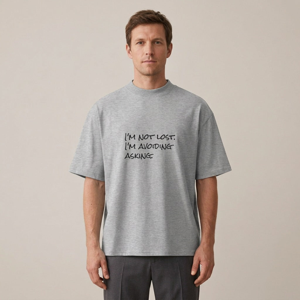 Man wearing the I'm Not Lost. I'm Avoiding Asking. t-shirt in heather grey