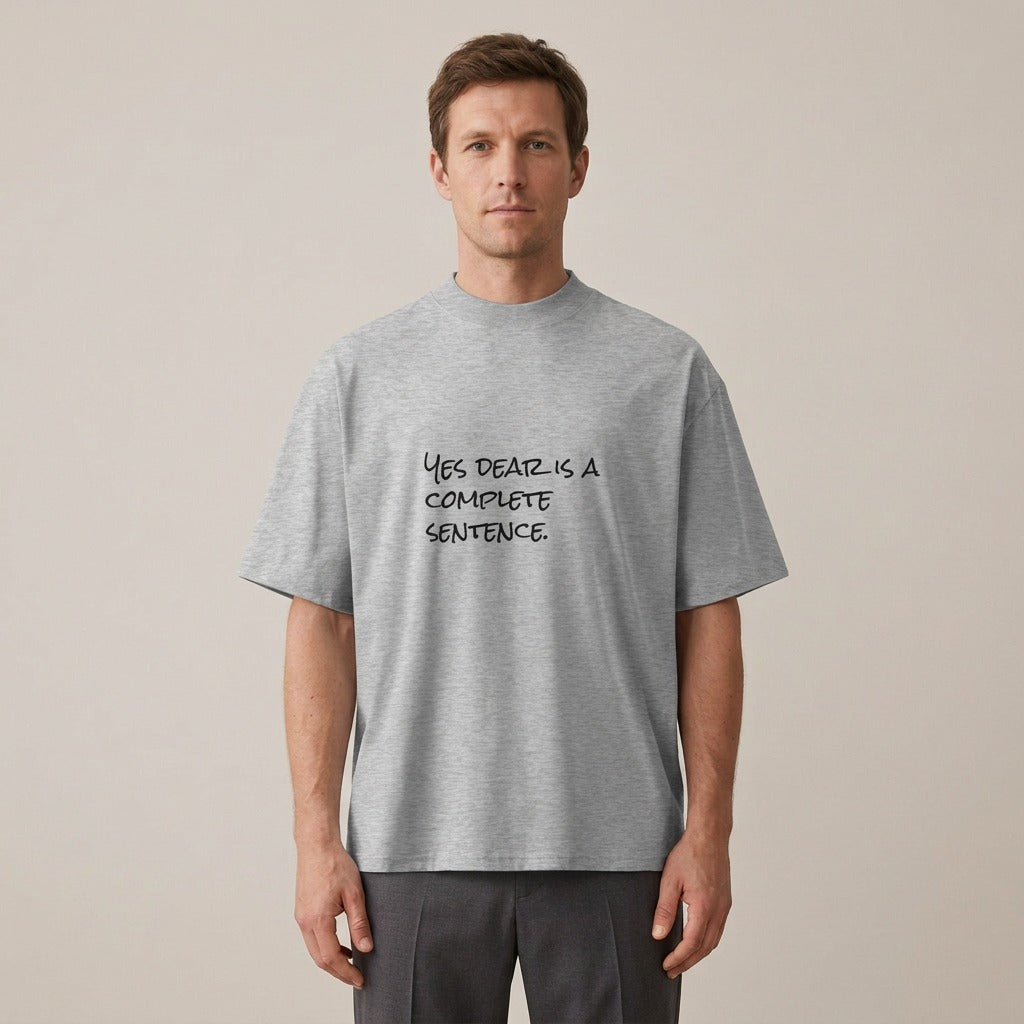 Man wearing the Yes Dear Is a Complete Sentence t-shirt in heather grey